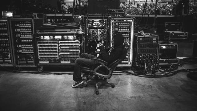 Technicien de spectacle aux commandes d'une régie lumière et son