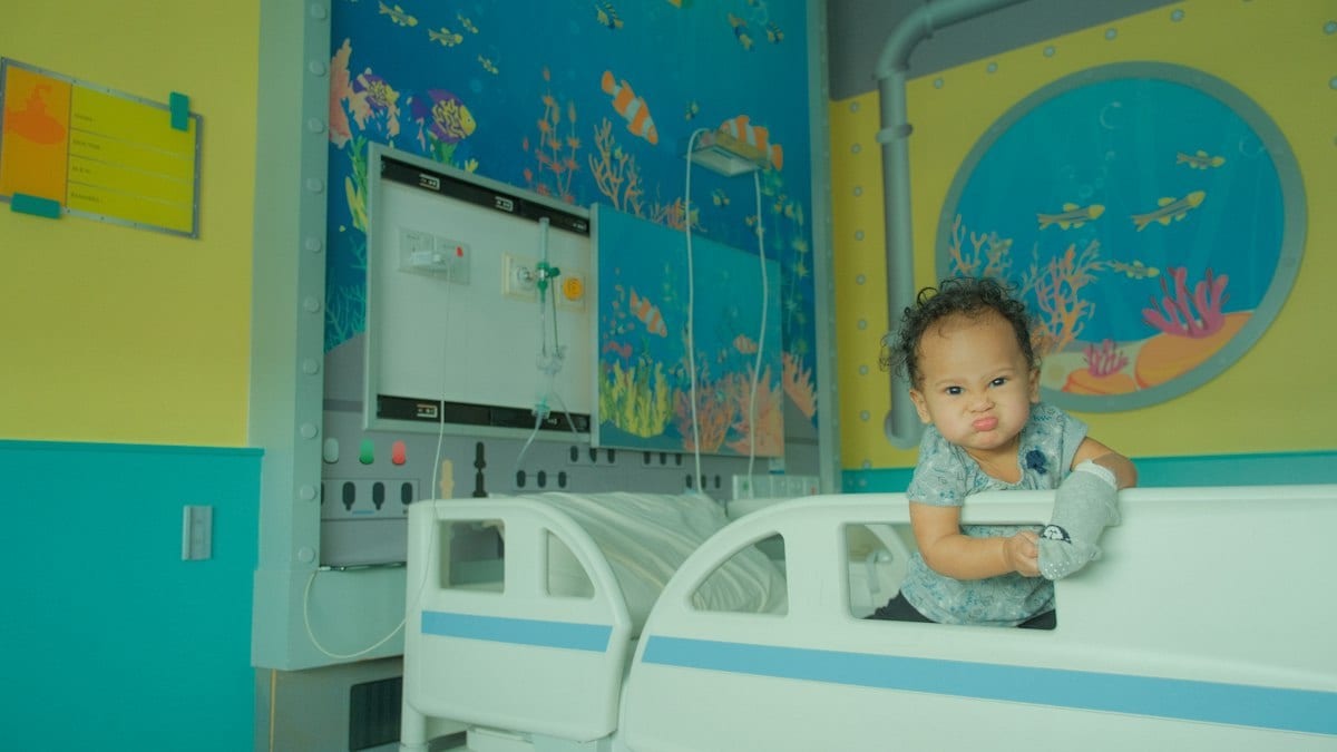 A baby sitting on a bed in a room