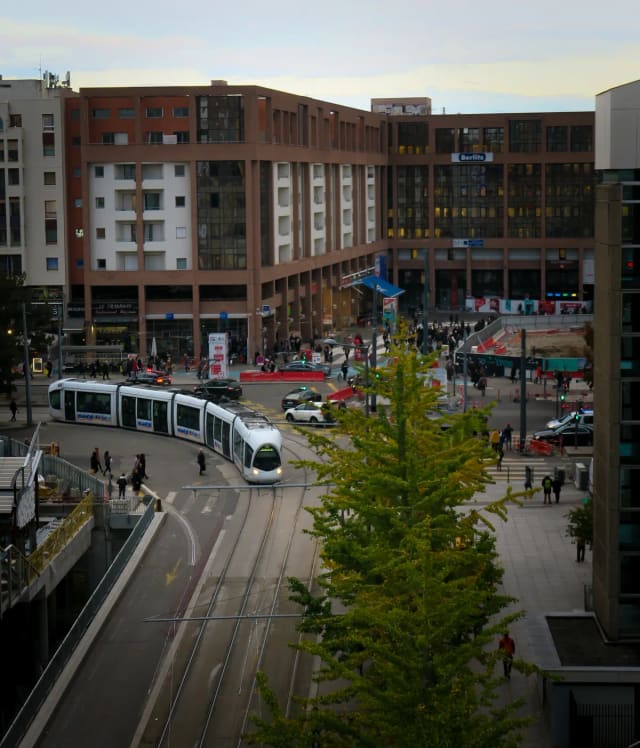 Un tramway circule dans une rue de Lyon, entre immeubles modernes