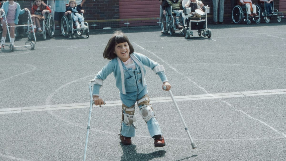 girl in blue and white striped long sleeve shirt and blue denim jeans holding walking stick