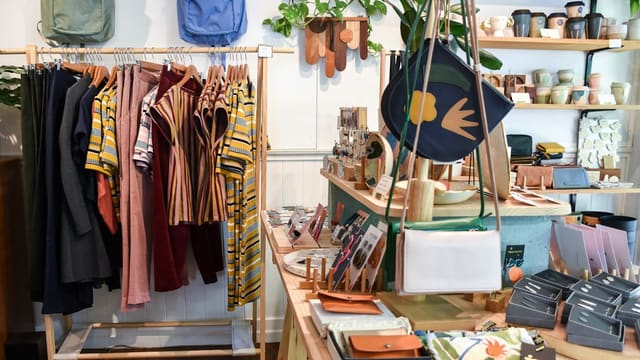 assorted-colored clothes on rack near brown wooden table