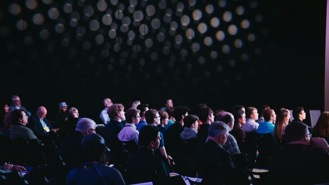 Un public assis dans une salle écoute une présentation, lors d'une rencontre chercheurs-grand public.