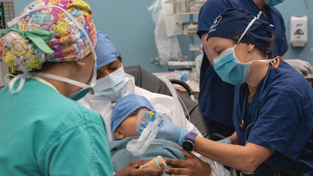 Medical team attends to newborn baby in hospital.