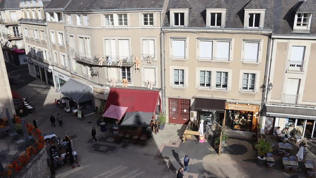 People walking on a street with buildings and shops.