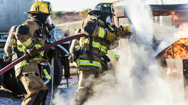 three fireman preventing fire during daytime