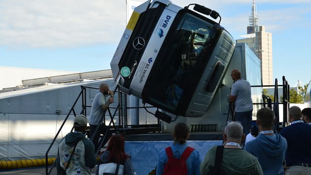 Groupe de personnes regardant une cabine de camion en équilibre vertical