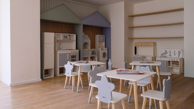 Children's playroom with small tables and chairs.