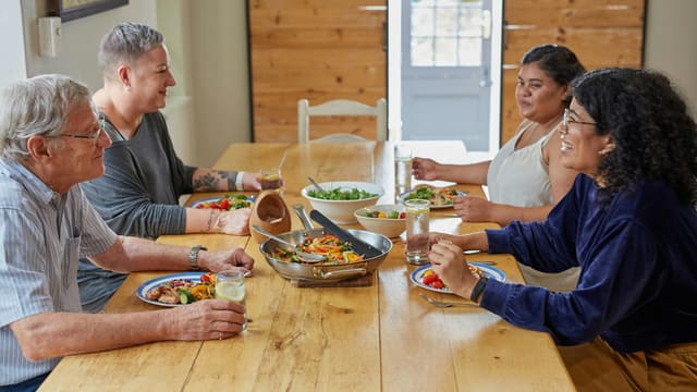 a group of people sitting around a wooden table