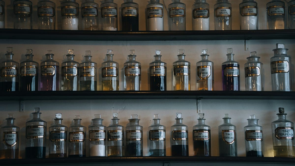 Rangées de pots de pharmacie en verre avec liquides colorés