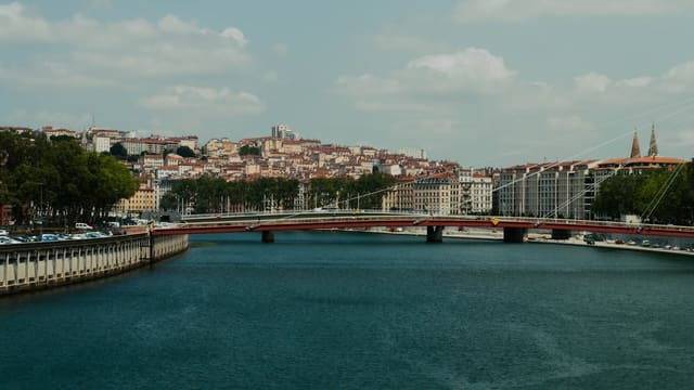 a bridge over a body of water with a city in the background