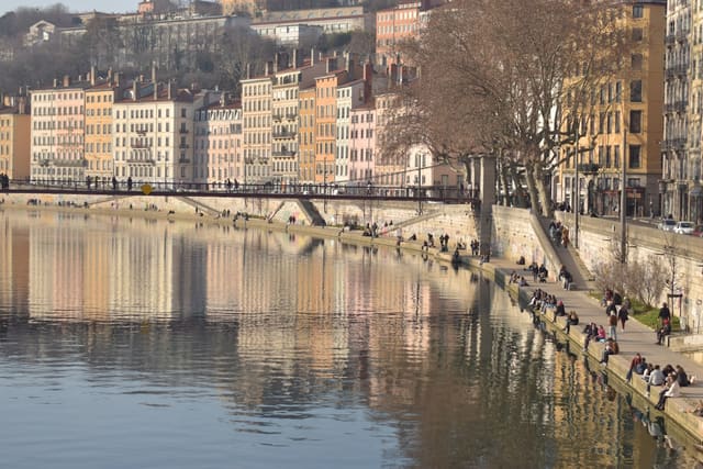 a group of people sitting on the side of a river