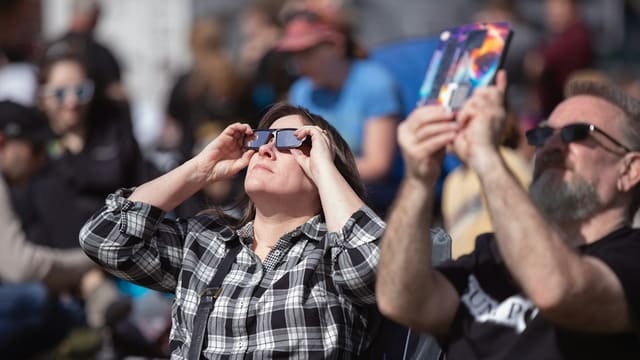 a woman looking through a pair of binoculars