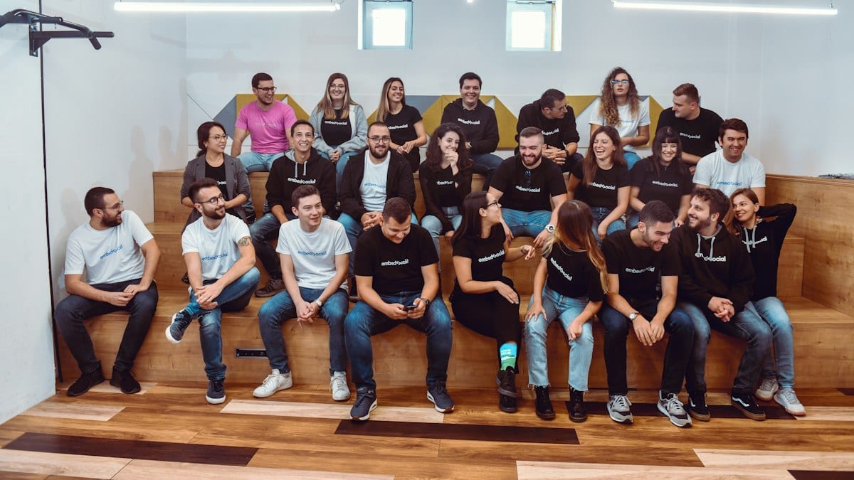a group of people sitting on top of a wooden bench