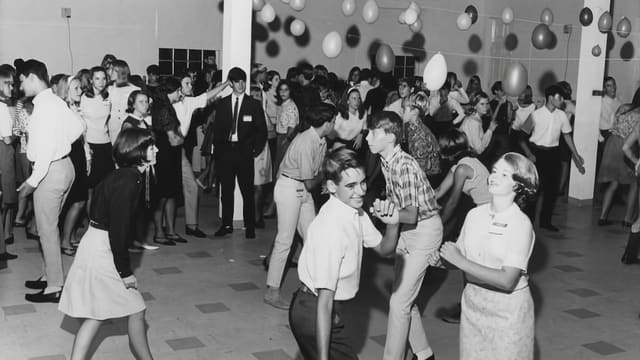 a black and white photo of a group of people dancing
