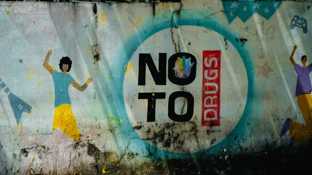 Graffiti art with "no to drugs" message and dancing figures.