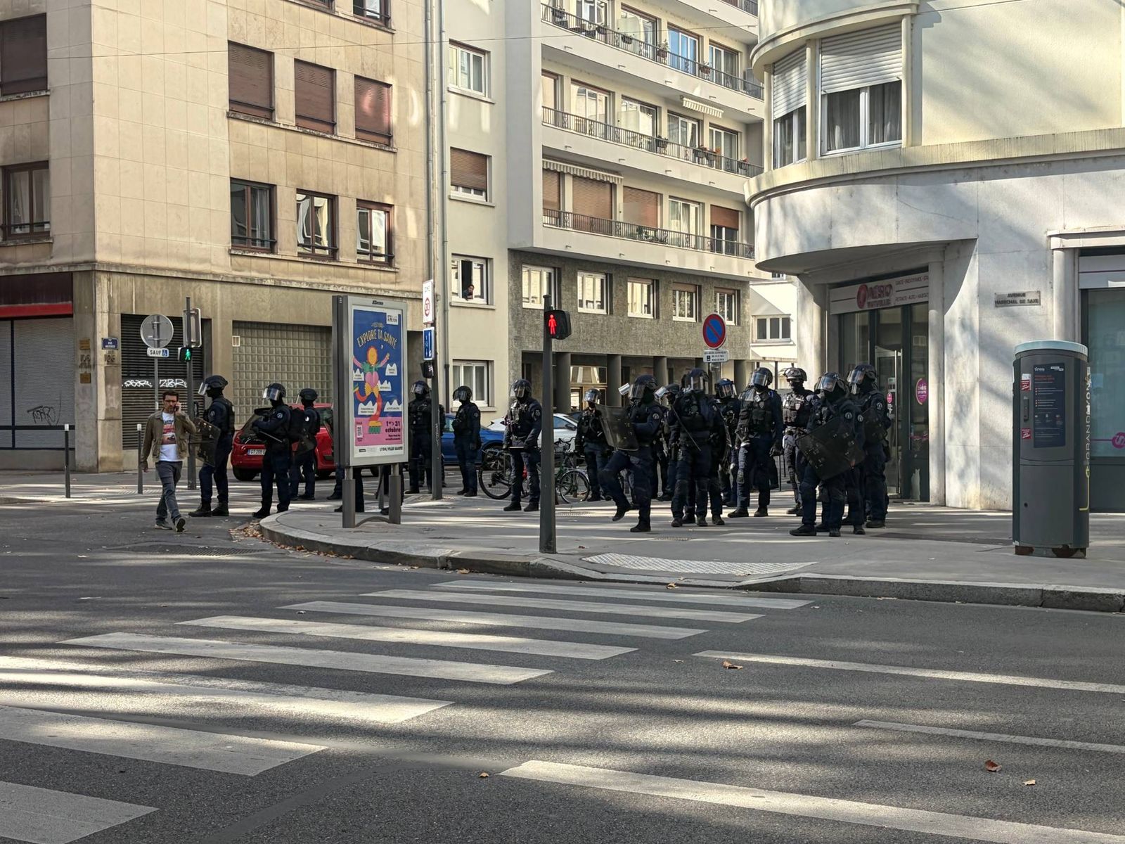 Une trentaine de policiers en tenue de maintien de l'ordre, boucliers en main, à un carrefour