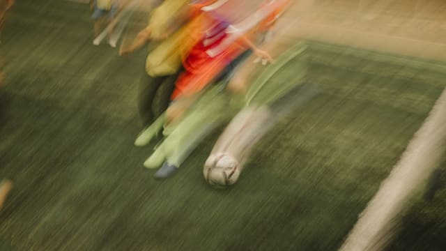 A blurry photo of a group of people playing soccer