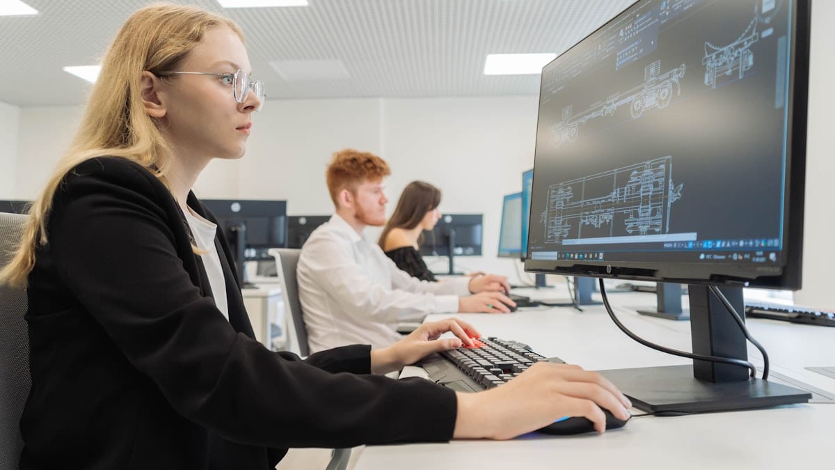 a woman sitting in front of a computer monitor
