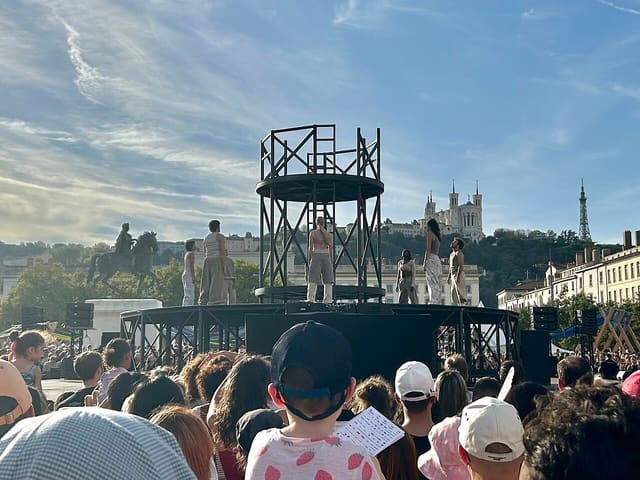 Performance chorégraphique sur la place Bellecour lors de la biennale de 2025.