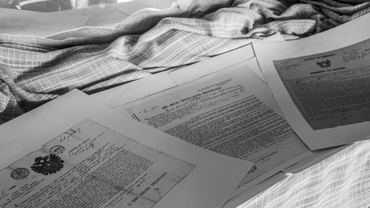 Documents d'archives anciens manuscrits photographiés en noir et blanc, évoquant le travail de conservation au cœur du spectacle Mémoires.