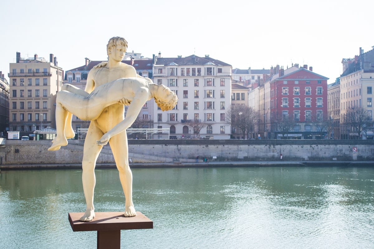 Statue de femme près d'un plan d'eau en journée.