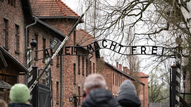 People visit the entrance gate of auschwitz.
