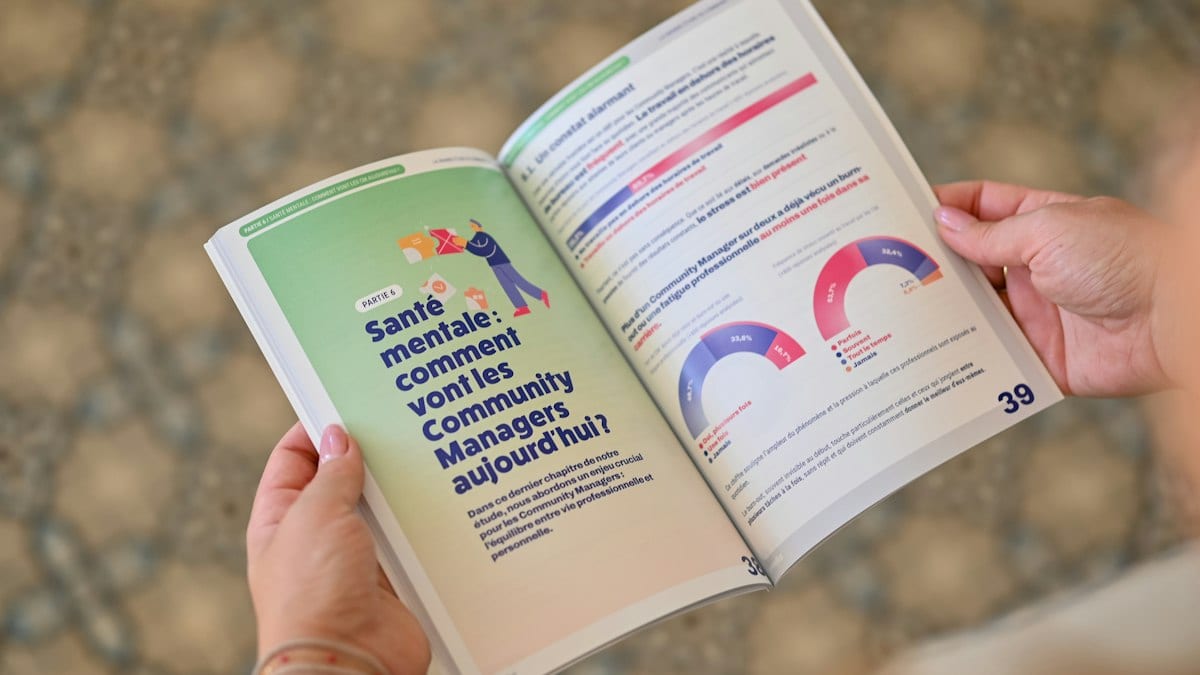 Person holding an open booklet with text and charts.