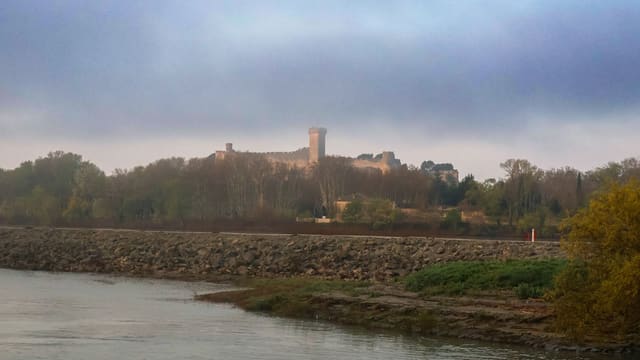 a large castle sitting on top of a hill next to a river