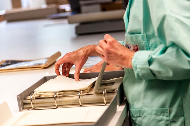 Classement aux Archives municipales de Lyon : une archiviste trie des documents iconographiques en salle de tri, 2013
