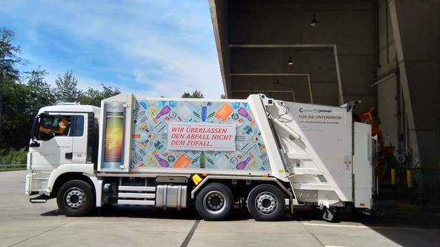 a garbage truck parked in front of a building