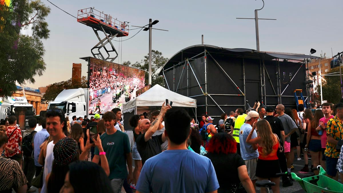 Crowd gathered at an outdoor event with stage and stage