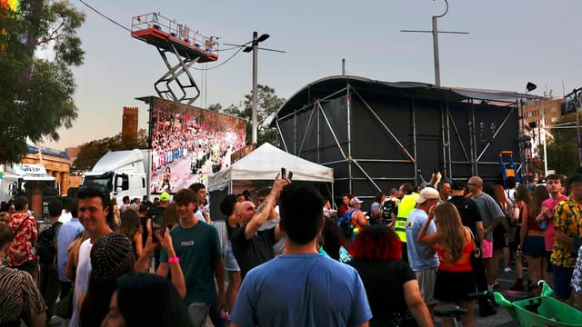 Crowd gathered at an outdoor event with stage and stage