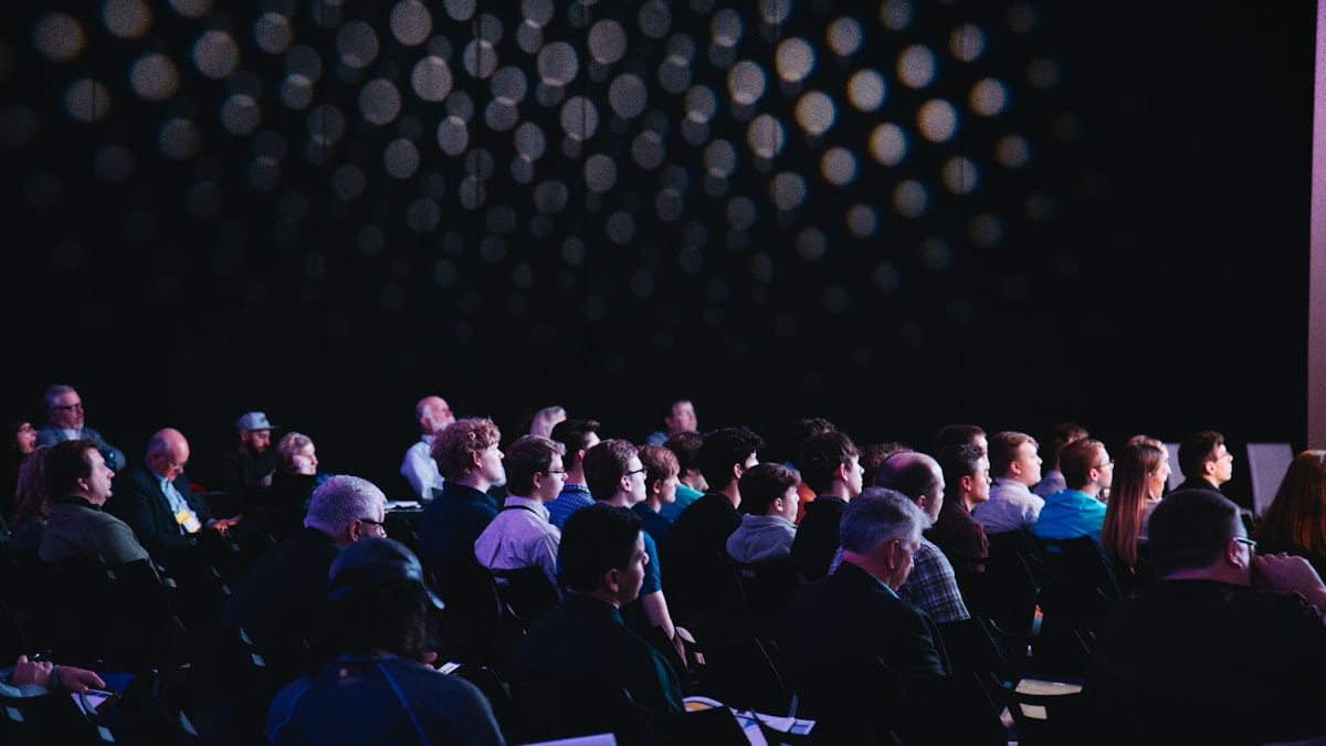 crowd of people sitting on chairs inside room