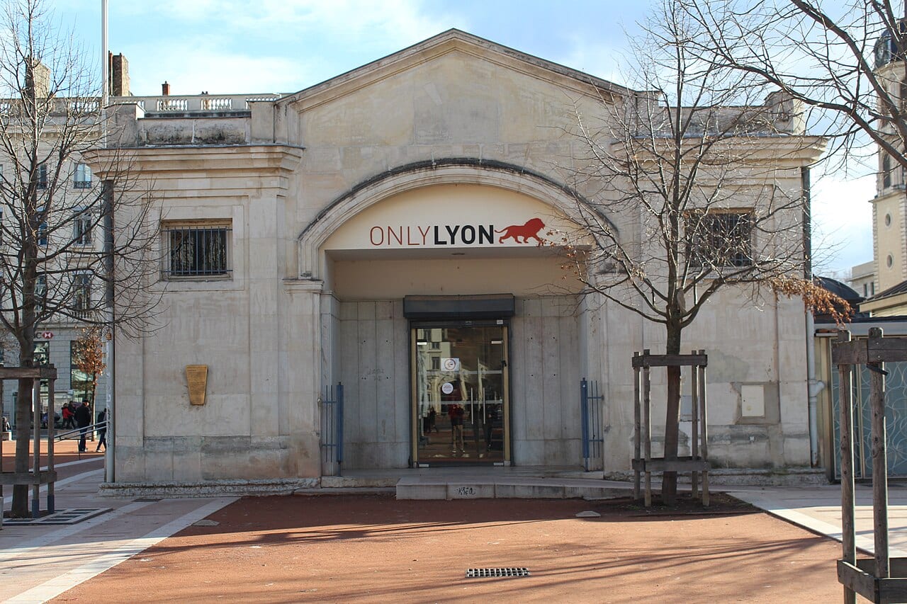 Le pavillon de pierre de l'office de tourisme, place Bellecour, photographié en décembre 2017, avec l'enseigne ONLYLYON au-dessus de son entrée vitrée.