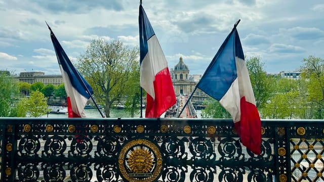 a fence with two flags on top of it