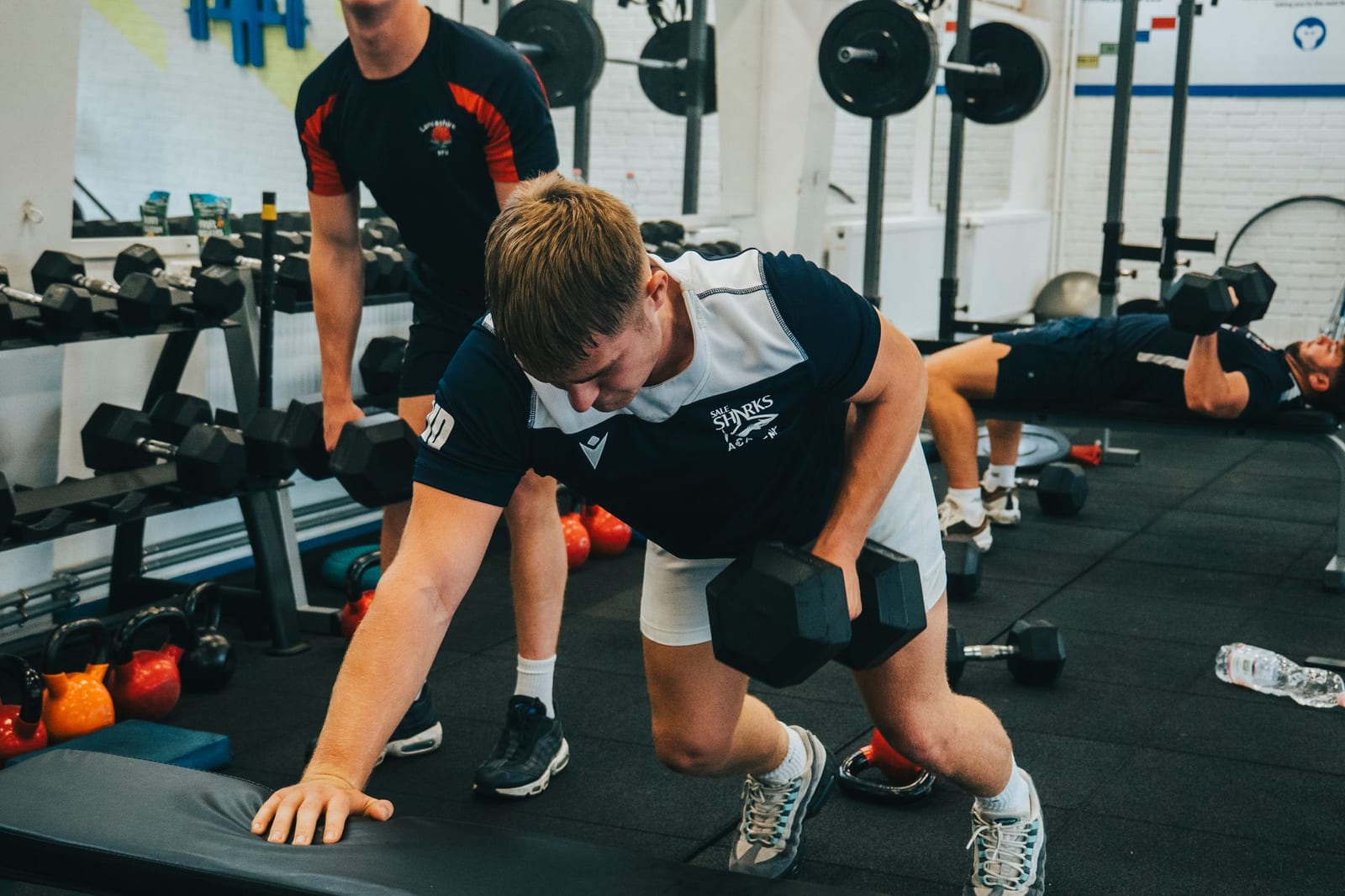 Hommes soulevant haltères musculation gym.