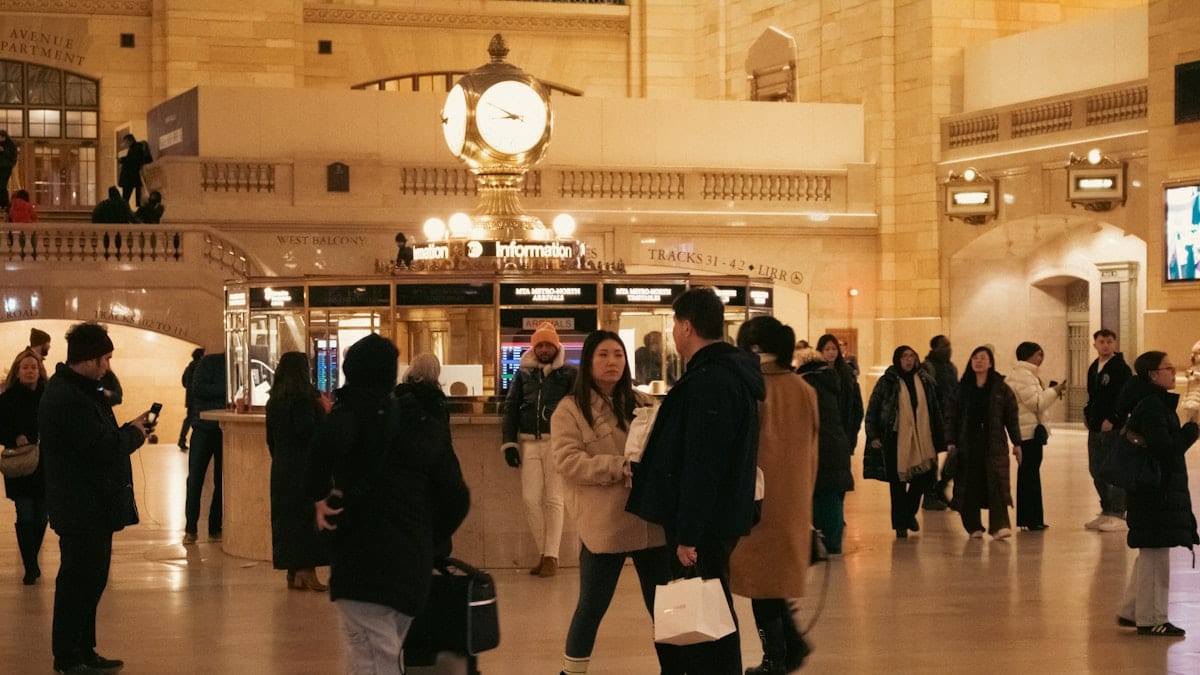 Personnes dans gare animée.