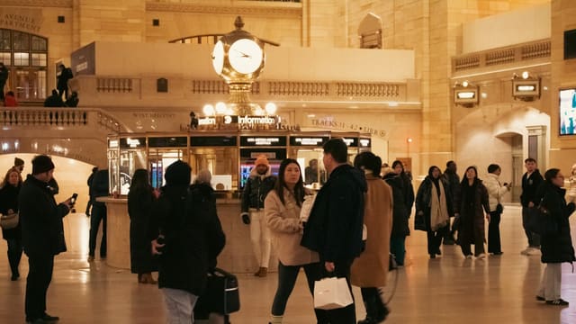 People are in a bustling train station.