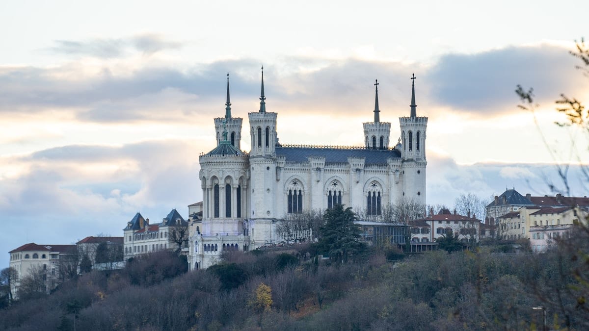 Grand bâtiment blanc en haut d'une colline.