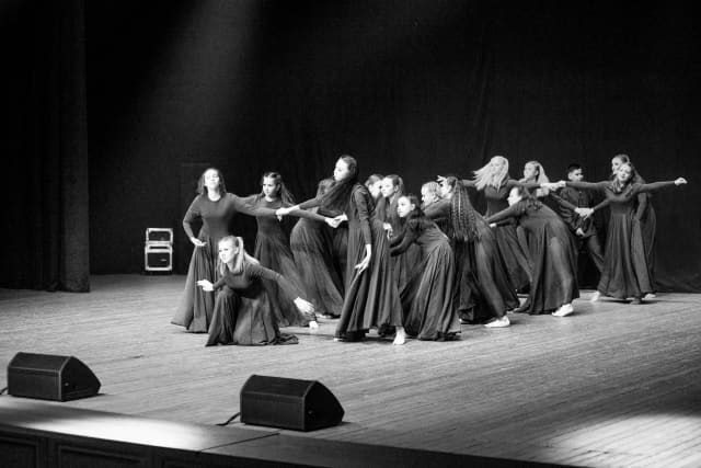 A striking black and white photo of dancers performing on stage, showcasing grace and artistry.