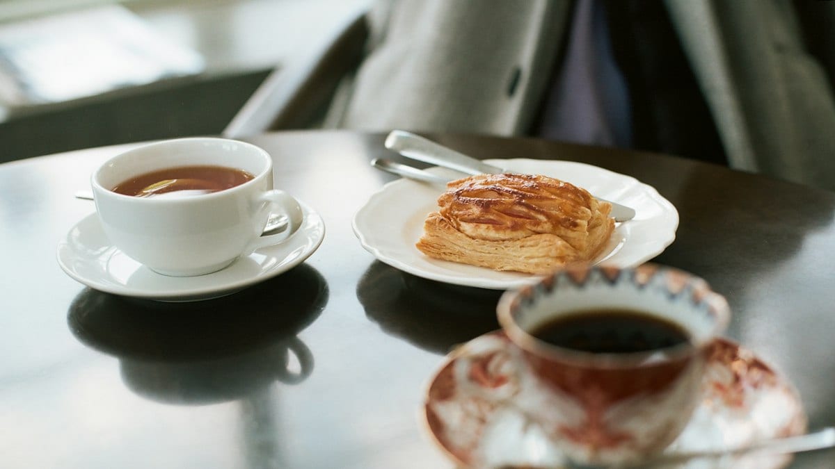 Pain sur assiette en céramique près d'une tasse de café blanc