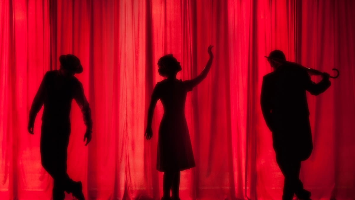silhouette of three performers on stage