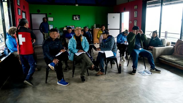A group of people sitting around each other in a room