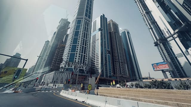 Modern skyscrapers rise against a clear blue sky.