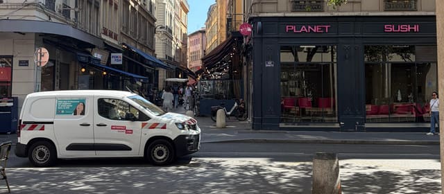 La rue Grenette à Lyon, chaussée réservée aux bus, vide hormis un utilitaire de la Métropole de Lyon