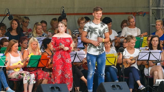 Young singers perform on stage with orchestra