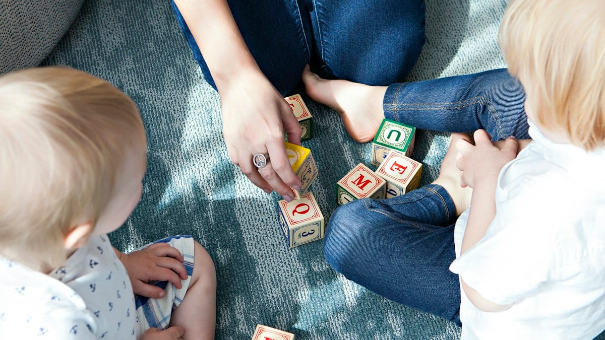 two toddler playing letter cubes