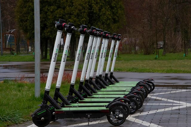 Trottinettes électriques en libre-service stationnées dans un parc urbain