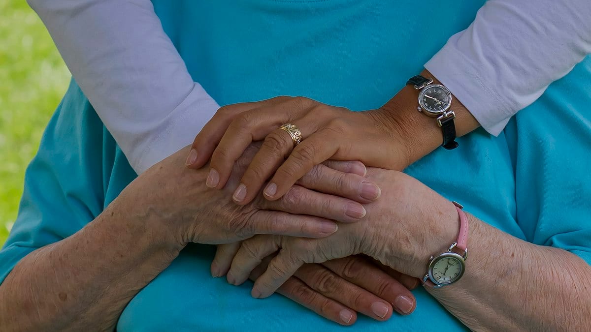 person wearing silver round analog watch
