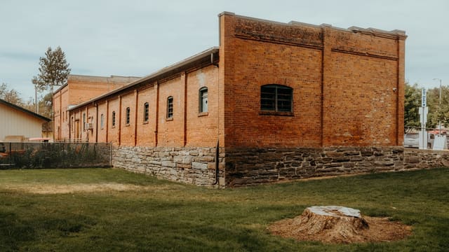 Old brick building with stone foundation and grassy yard